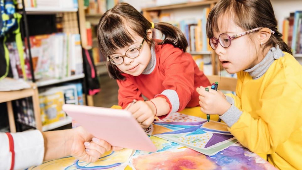 Zwei Mädchen mit Downsyndrom beim Malen