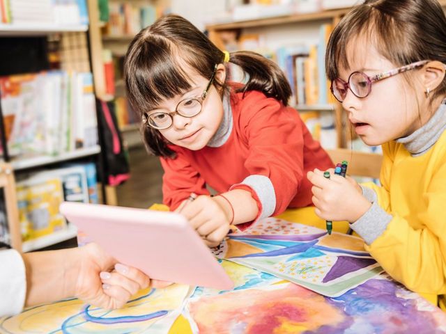 Zwei Mädchen mit Downsyndrom beim Malen