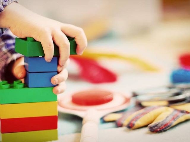 Kinderhände die mit bunten Bauklötzen spielen