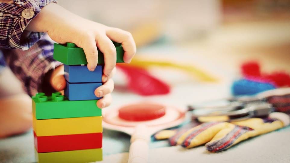 Kinderhände die mit bunten Bauklötzen spielen