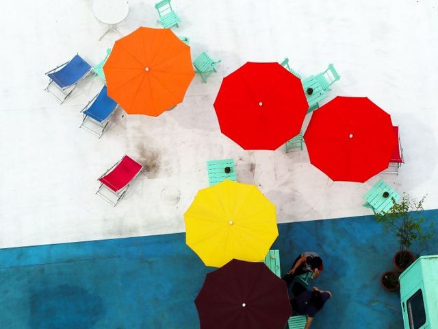 Bunte Sonnenschirme auf einer Dachterrasse, von oben gesehen