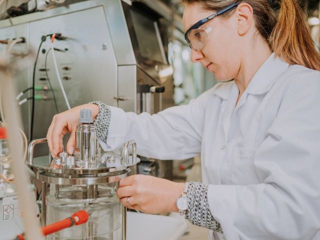 Wissenschaftlerin an einem Bioreaktor