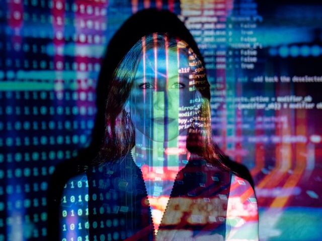 Software-Entwicklerin, auf die ein farbiger Code projiziert wird