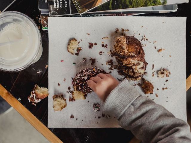 Kinderhand, die nach Kuchen greift