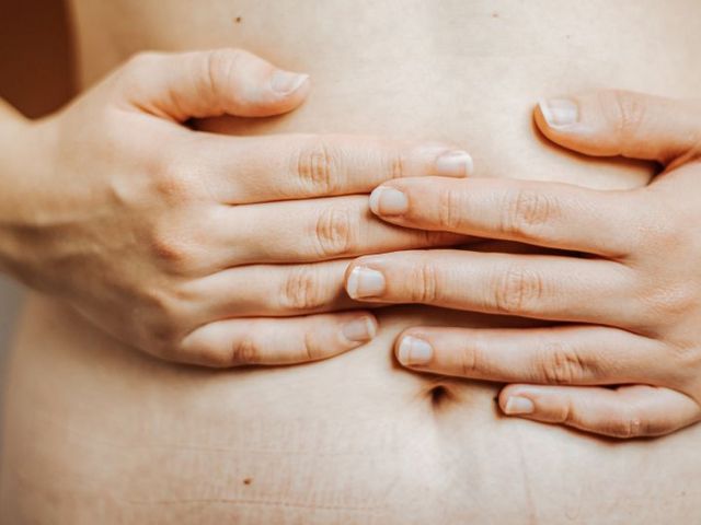 Hands resting on the belly.