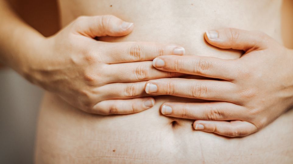 Hands resting on the belly.
