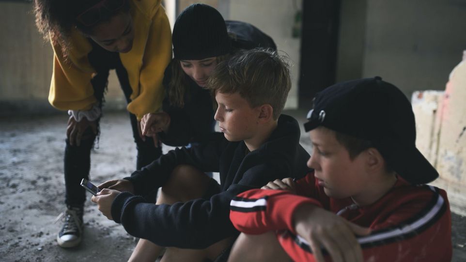 Gruppe Jugendlicher, über ihre Smartphones gebeugt