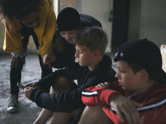 Gruppe Jugendlicher, über ihre Smartphones gebeugt