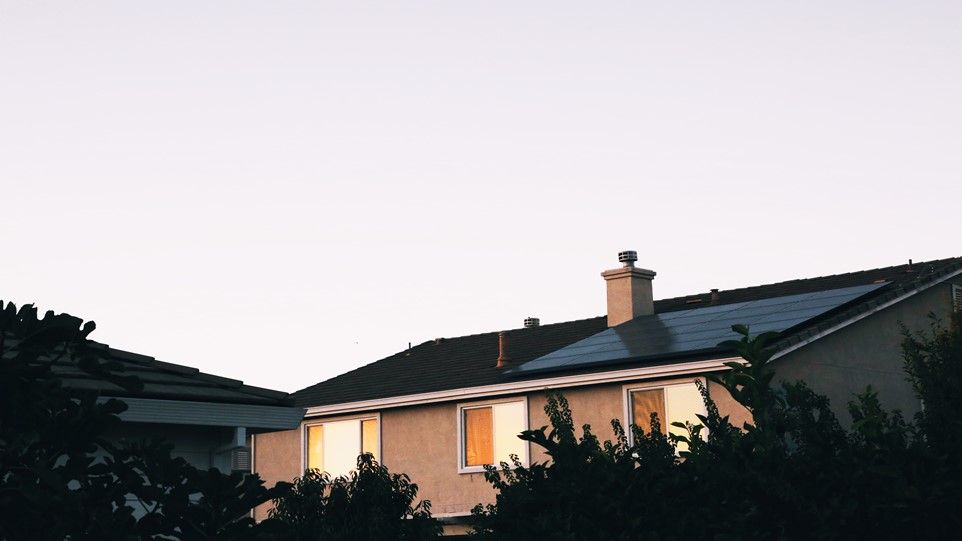 Mehrfamilienhaus in Abendstimmung mit Solarzellen auf dem Dach