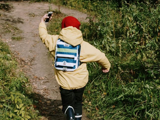 Kind mit Smartphone von hinten