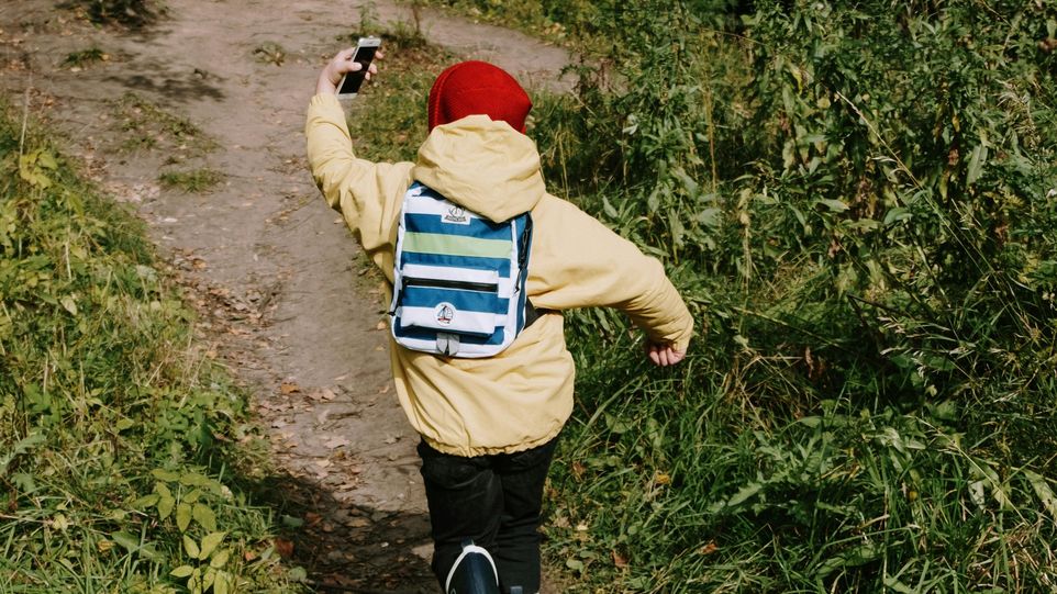 Kind mit Smartphone von hinten