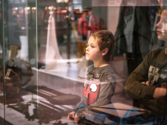 Zwei Jungen vor der Vitrine eines Museums mit alten Gegenständen