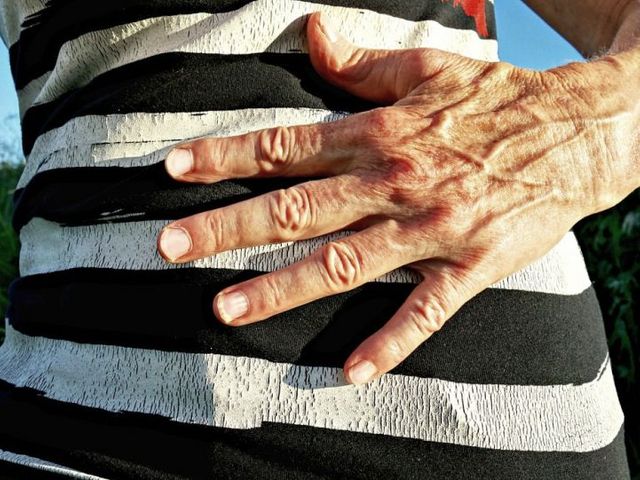 Unterkörper mit daraufgelegter Hand