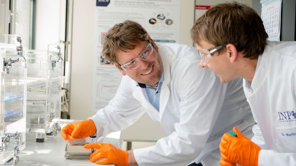 Gustav Sievers (links) und Martin Rohloff von elementarhy kontrollieren die neuartige Membran-Elektroden-Anordnung für Wasser-Elektrolyseure. Die beiden Preisträger