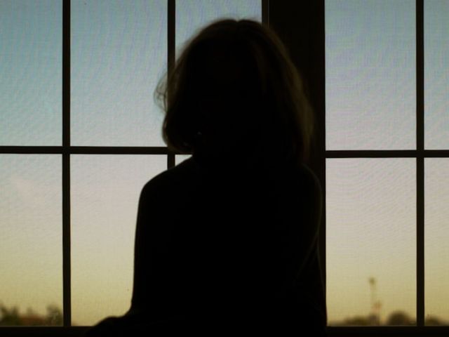 Frauensilhouette vor einem Fenster