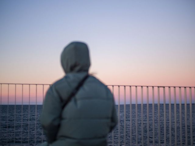 Rückansicht einer Person, die aufs Meer blickt