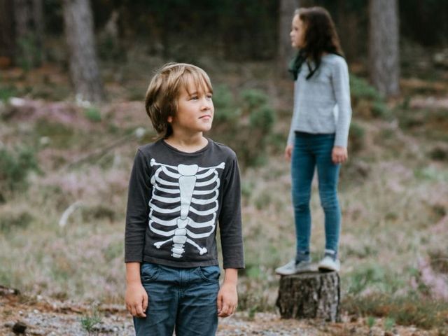 Zwei Kinder auf Baumstümpfen im Wald