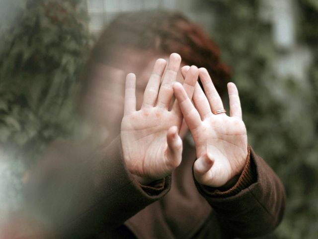 Frau, die die Hände abwehrend ausstreckt