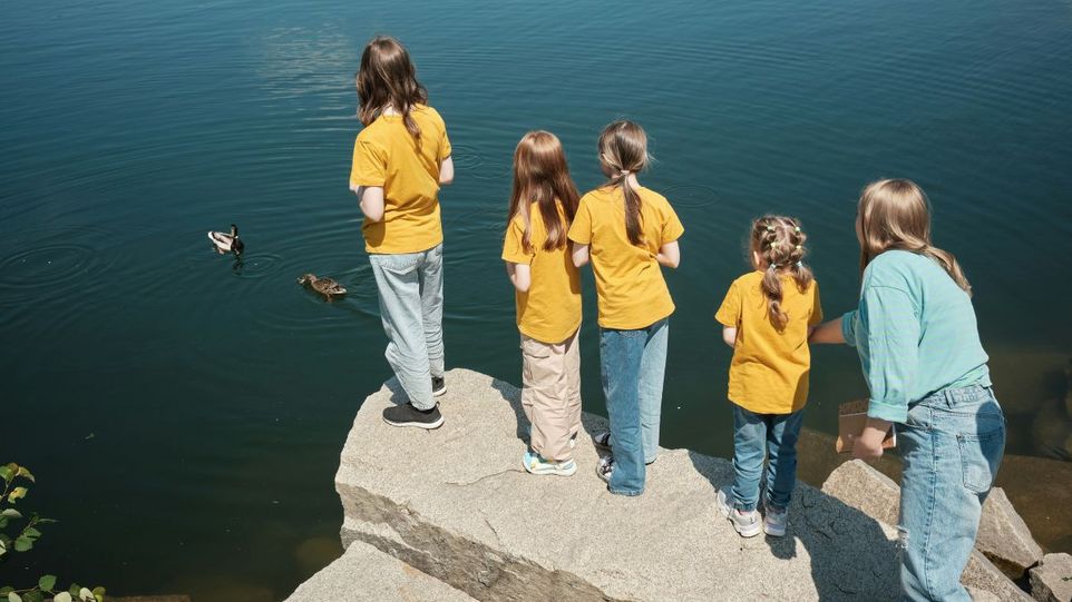 Mutter mit vier Kindern an einem See