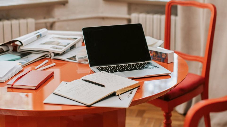 Tisch mit Laptop und Schreibutensilien