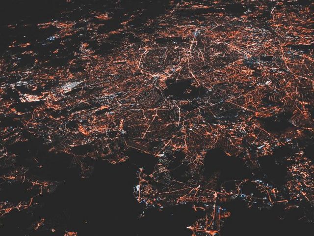 Nächtliche Luftansicht einer Stadt mit Ausläufern