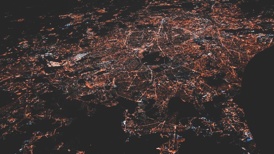 Nächtliche Luftansicht einer Stadt mit Ausläufern