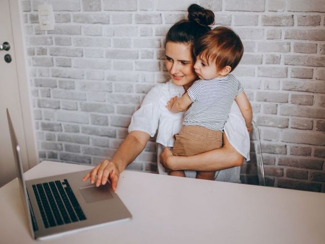 Frau mit Kind und Laptop