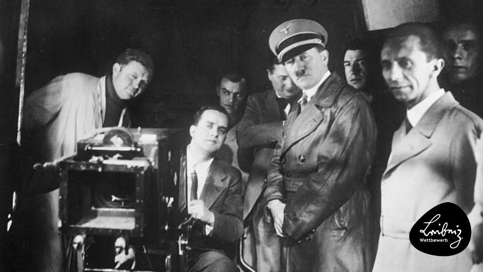 Hitler und Goebbels besuchen ein UFA-Filmset, 1935 Schwarz-weiß-Foto von Hitler und Goebbels mit Filmteam und Kamera