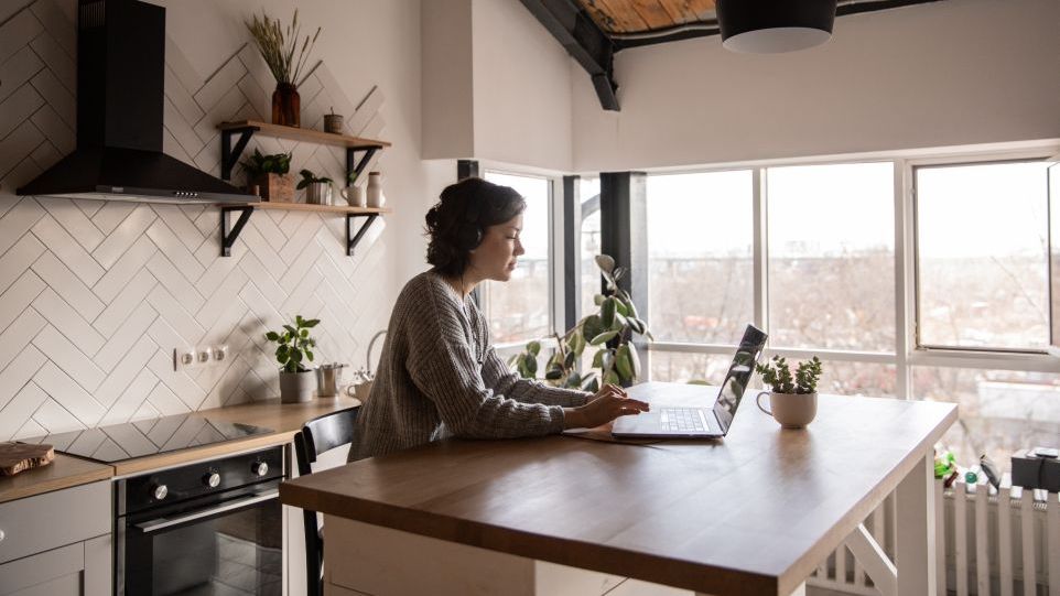 Woman working on the laptop at the kitchen table