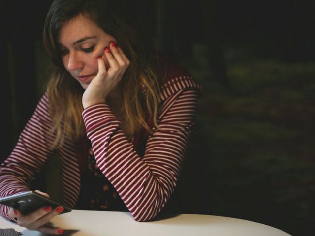 Junge Frau blickt aufs Handy