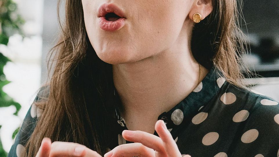 Frau formt mit ihrem Mund ein O