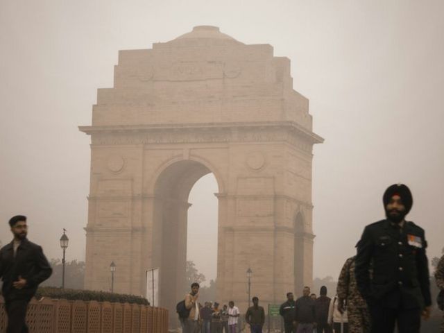 India Gate umhüllt von Nebel und umgeben von Menschen