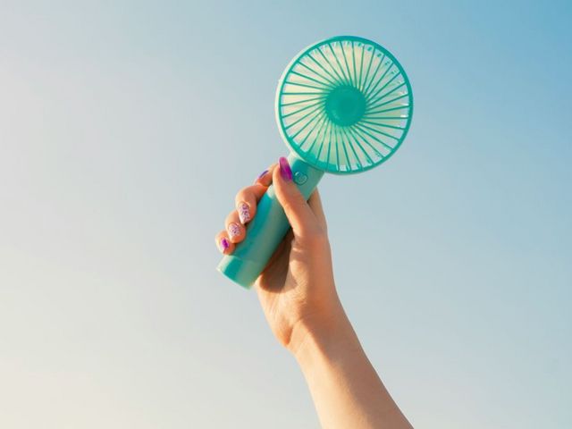 A hand is holding a handheld fan