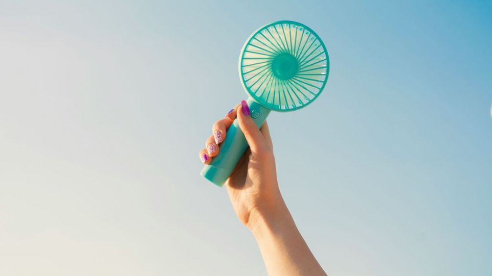 A hand is holding a handheld fan