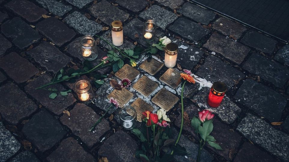 Stolpersteine mit Kerzen und Rosen