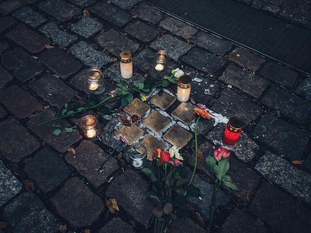 Stolpersteine mit Kerzen und Rosen