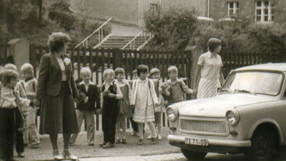 Schulkinder mit zwei Lehrerinnen in der DDR