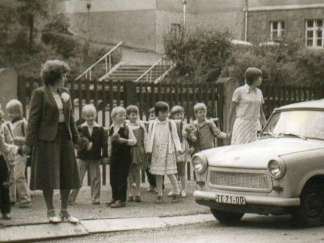 Schulkinder mit zwei Lehrerinnen in der DDR