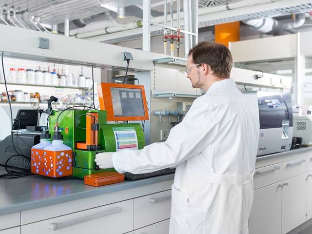 Wissenschaftler steht im Labor und arbeitet an grünem Messgerät