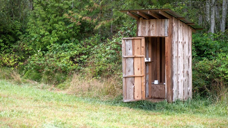 Toilettenhäuschen auf einer Wiese