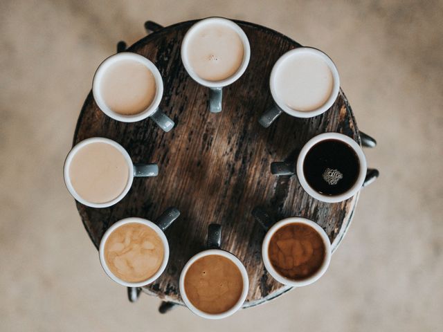 Acht Kaffeetassen gefüllt mit verschiedenen Kaffeearten