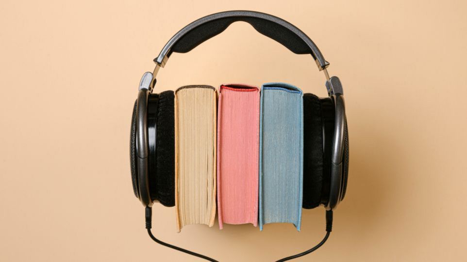 Kopfhörer mit eingeklemmten Büchern