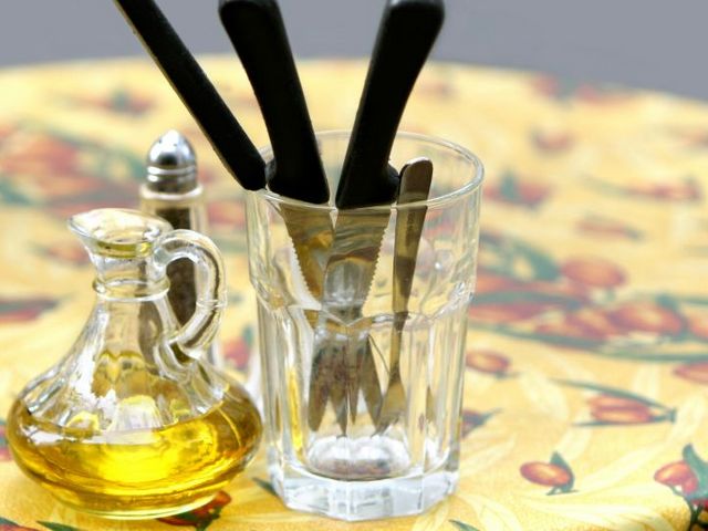 Ein Tisch gedeckt mit einem Ölkännchen, einem Pfefferstreuer und Besteck