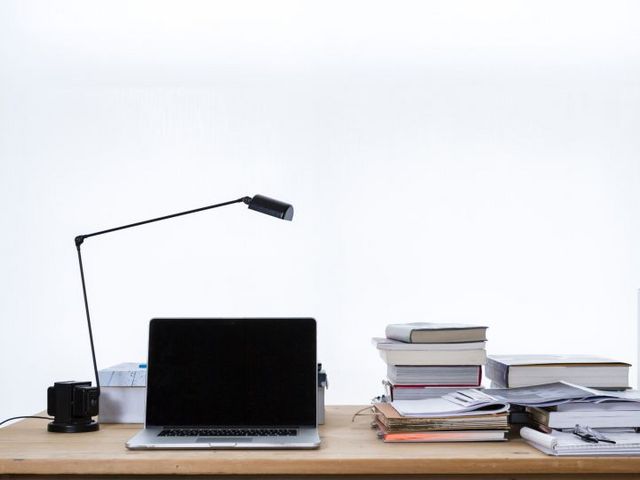 Schreibtisch mit Büchern und Laptop