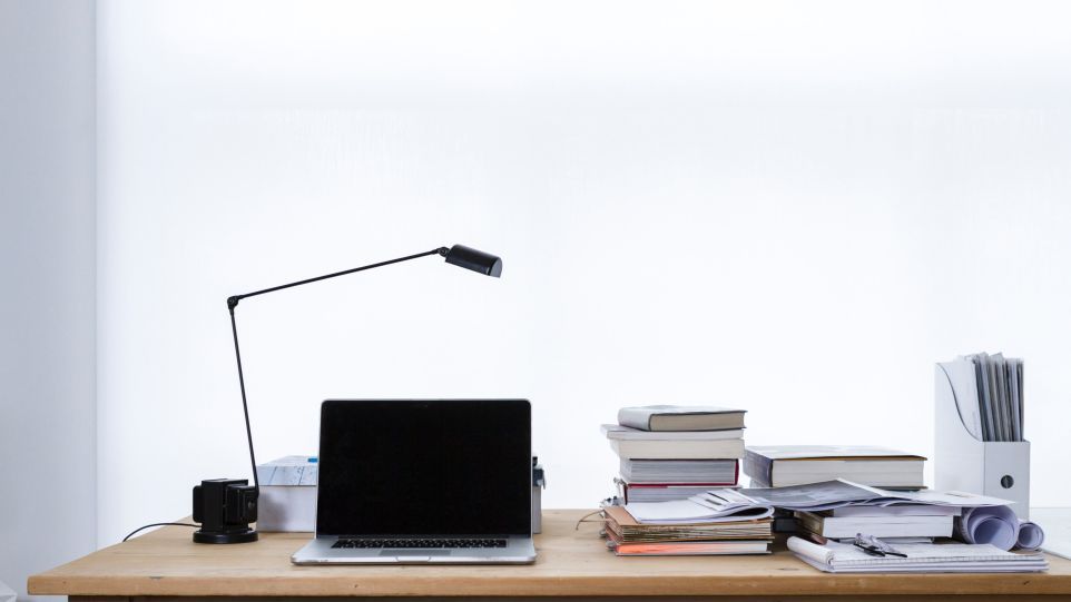Schreibtisch mit Büchern und Laptop