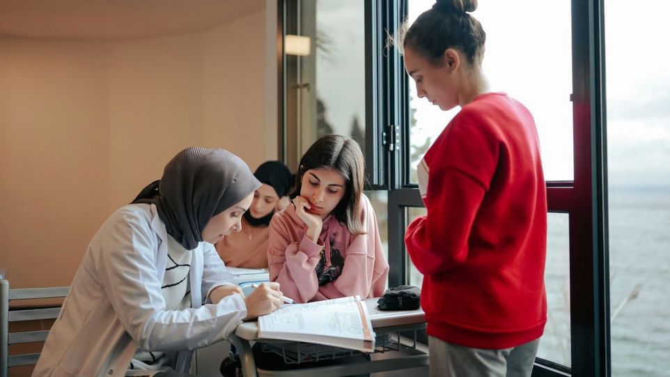 A teacher with three pupils in the classroom
