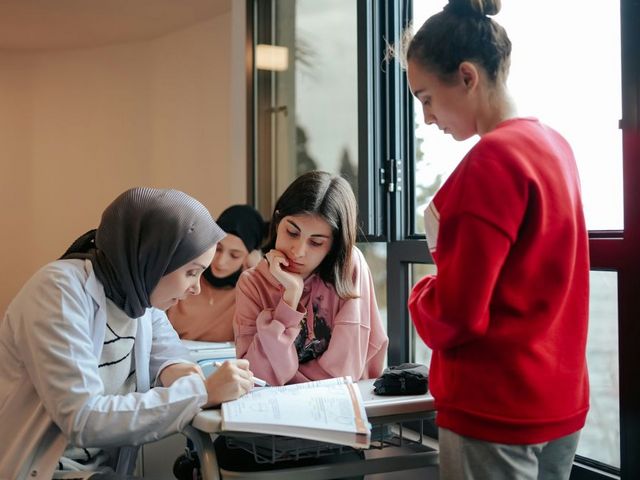 A teacher with three pupils in the classroom